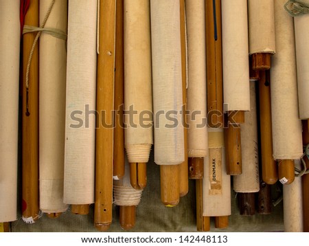 Rolled-up maps on wooden sticks seen from above lying on table
