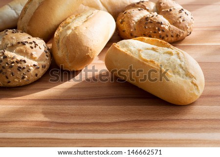 Fresh bread rolls on wooden cutting board