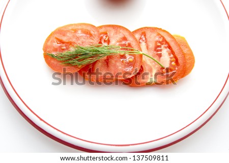 Sliced Tomatoes with green Dill on Plastic Plate