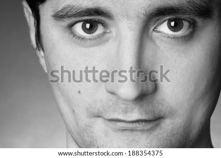 close up portrait of a young happy man, black and white studio shot