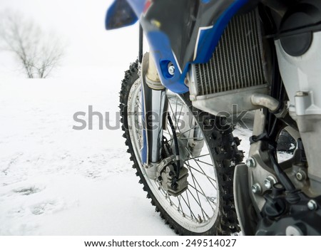 Close up of a front wheel and suspension of a sport bike on a snow, outdoor shot