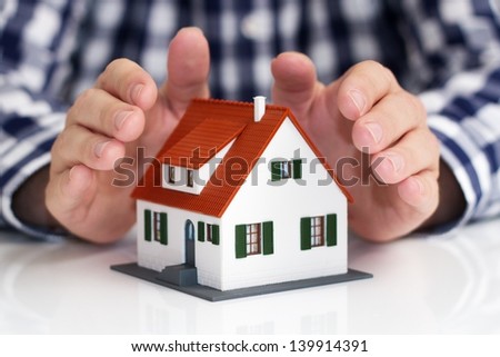 Hand over mini house with depth of field