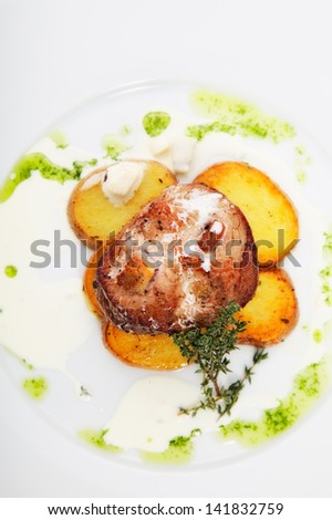 roast meat with potatoes on white plate