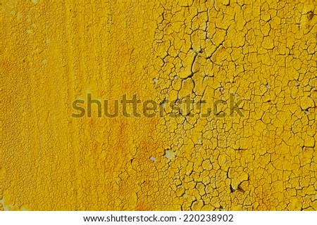 Yellow cracked paint on metal rusty surface