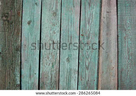 Wooden Palisade background. Close up of grey and green wooden fence panels.