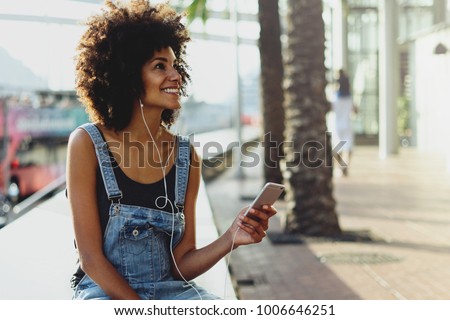 Similar – Foto Bild Junge Afrofrau, die mit Kopfhörern Musik hört.