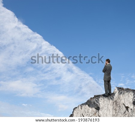 man on top of a rock watching the clouds