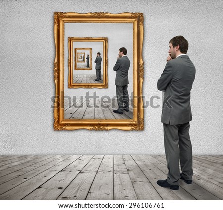 Young businessman looks at himself in the mirror