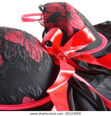 The top of black lingerie with red strings closeup on white background