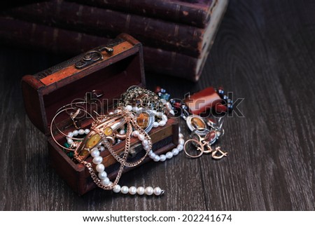 Nice vintage open box full of various jewelry on dark wooden background