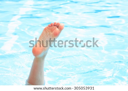Swimming enjoying. Female foot in outdoor swimming pool