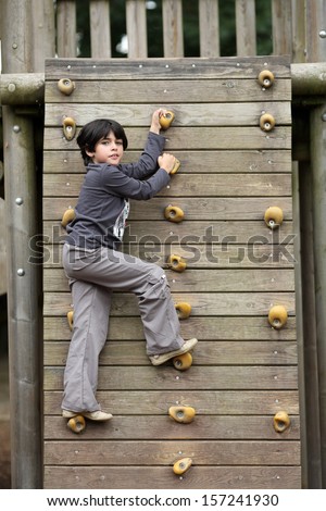 Details of an outdoors climbing girl on a climbing wall for kid.