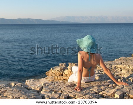 Woman wearing linen pants and straw hat. Croatia.