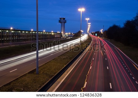 traffic lights at night on highway with airport tower of the liege airport