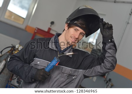 Similar – Image, Stock Photo A man welder with construction gloves and a welding mask hard work and welds with a welding machine metal in workshop, close up