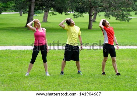 Group of three young health athletes doing stretching exercise relaxing and warm up after jogging and running in park