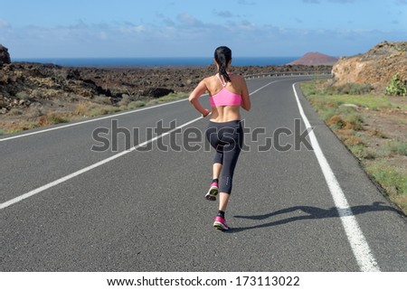 Runner woman running on mountain road in beautiful nature, volcanic landscape on Canary islands