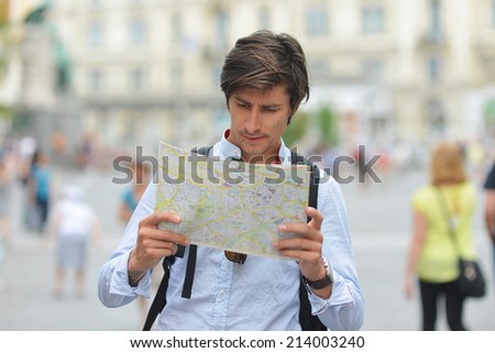 Young tourist watching the map in the city center