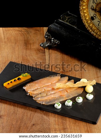 Fine dining, smoked salmon with mango jelly on black slate