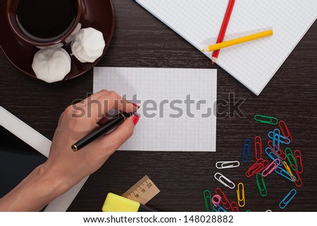 woman\'s hand writing on paper