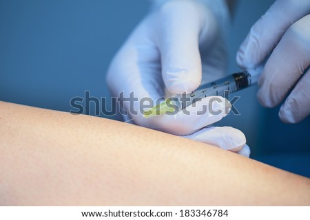 Doctor making injection to patients leg