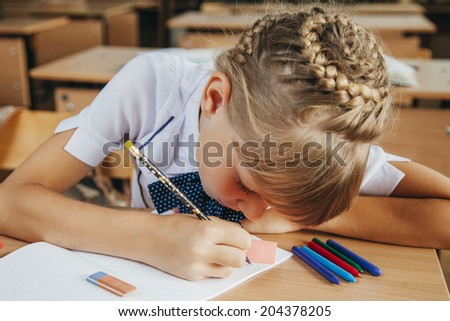 little girl at the desk is writing