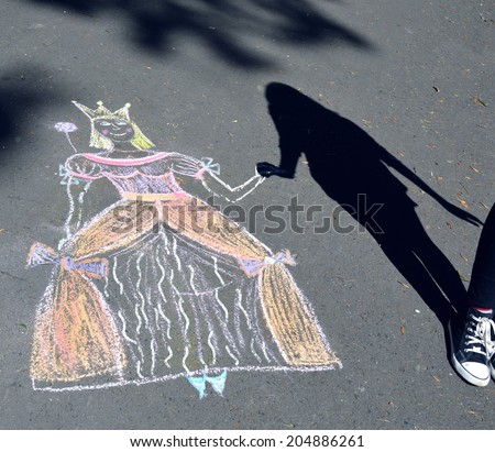 Girl playing with drawn princess in park.