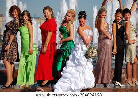 Moscow, Russia - September 22, 2007: The bride and her bridesmaids in colorful dresses photographed against the backdrop of fountains. 
Fountains are very popular in Moscow for weddings.