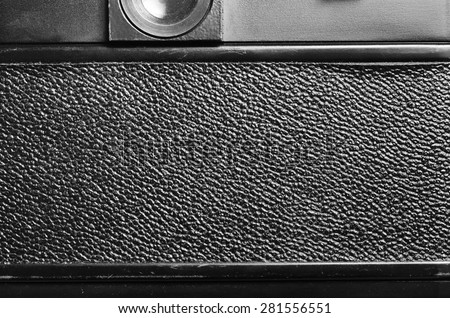 Back part of the film dslr camera with a cover the covered skin. Close-up view. Macro. Vintage photo. Black and white.