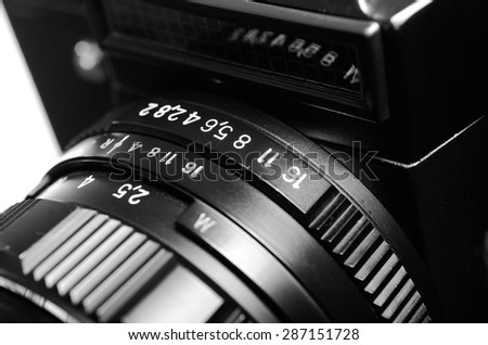 Old film DSLR camera with lens. The scale of the aperture, depth of field and distance. Close up view. Macro. Selective focus. Vintage photo. Black and white.