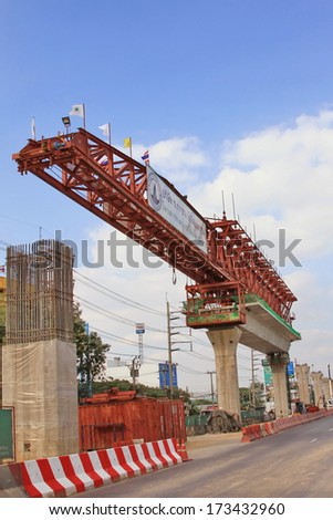 BANGKOK - DECEMBER 19 : The construction of electric railway carriage way over the head of the sky train, with a large crane on a central street in Bangkok on December 19, 2013 in Thailand.