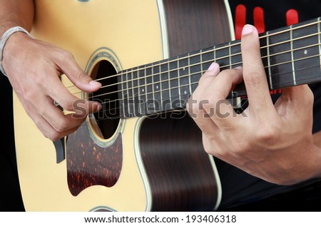 Male hand playing acoustic guitar.guitar play.Close up of guitarist hand playing acoustic guitar