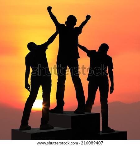 Champion on the podium team silhouette achievements successful young men at sunset athlete with arms up celebrating success sport goals after exercising and working out active life concept.
