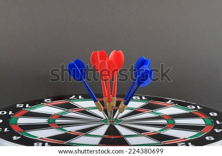 The goal of business is intended to accomplish as a team darts on dark gray background with arrows, middle target.
