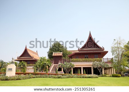 Wooden House high pitched roof elevated central Thailand Landscaped gardens, a large family residence.
