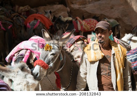 PETRA, JORDAN - APRIL 9, 2014 - Undefined Jordan man offers donkey ride to tourists on April 9, 2014 in Petra.