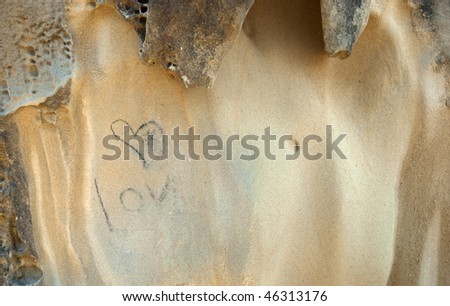 A message of love slowly gets washed away from the face of a sandstone.