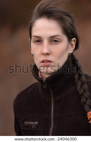 Portrait of serious pretty girl on blurry brown background - shallow DOF
