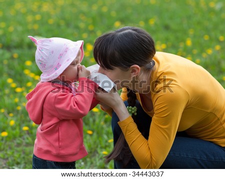 Little girl with her mom suffer from allergy - shallow DOF, focus on girl's eyes