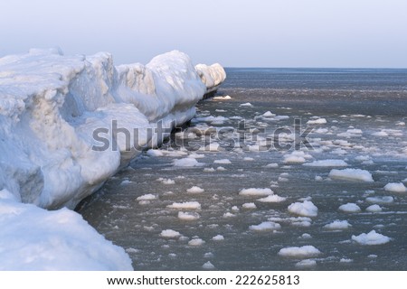 Winter at the Baltic Sea during twilight. Piled up Ice Floe on the Baltic Sea, Usdeom Island, Germany. Cold winter day on the Baltic Sea with frozen breakwater.