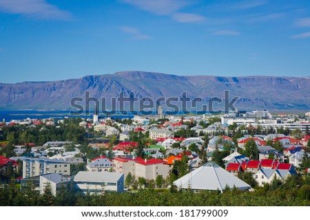 Beautiful super wide-angle aerial view of Reykjavik, Iceland with harbor and skyline mountains and scenery beyond the city, seen from the observation tower of Hallgrimskirkja Cathedral.