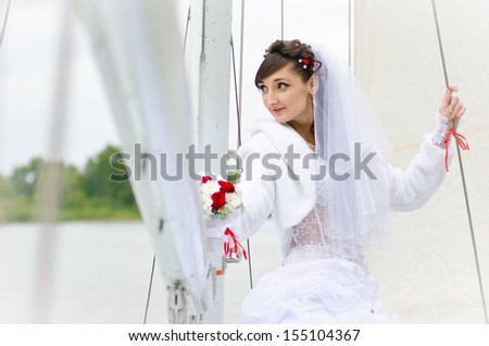Bride on a yacht with white sails. Wedding at the sea on a yacht.