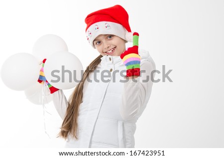 girl in a red cap and colored gloves holding white balloons. Christmas. joy, surprise