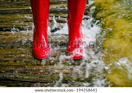 red rubber boots in the water, the river overflowed its banks.