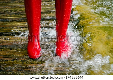 red rubber boots in the water, the river overflowed its banks.