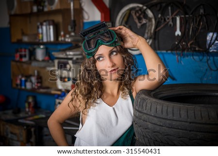 Female mechanic at work. auto service station, working girl. girl with curly hair in working clothes. woman working in the garage