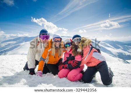 happy family in winter clothes lie on the snow at ski resort