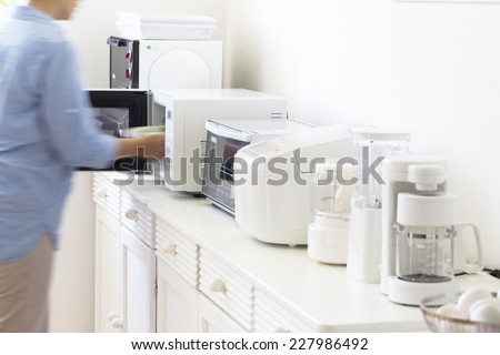 Housewife cooking in a small cooking appliances