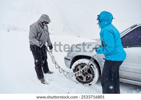 Similar – Image, Stock Photo Woman putting security snow chain in tire wheel of car