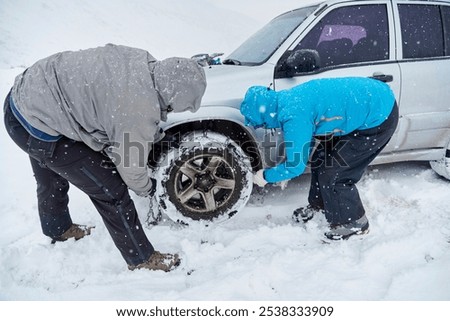 Similar – Image, Stock Photo Woman putting security snow chain in tire wheel of car